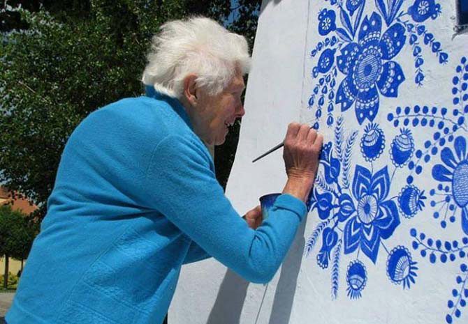 87-летняя старушка искусно расписывает фасады домов