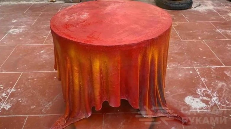 Столик из велосипедного колеса, куска ткани и цемента