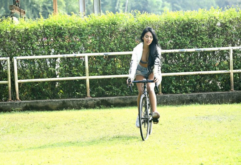 Миловидная азиаточка на велосипеде